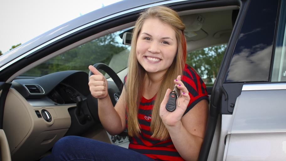 teenage girl with car keys sitting in a car
